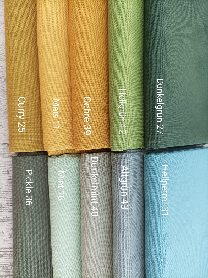 May include: Fabric swatches in various shades of green, blue, and yellow. The swatches are labeled with names and numbers, such as "Curry 25", "Mais 11", "Ochre 39", "Hellgr&uuml;n 12", "Dunkelgr&uuml;n 27", "Hellpetrol 31", "Altgr&uuml;n 43", "Dunkelmint 40", "Mint 16", and "Pickle 36".
