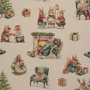 Könnte beinhalten: Ein beiger Stoff mit einem sich wiederholenden Weihnachtsmuster aus Waldtieren, darunter singende Hasen, ein Bär im Schaukelstuhl vor einem Kamin, ein Eichhörnchen mit Geschenken, eine Katze im Weihnachtsstrumpf und verpackte Geschenke.