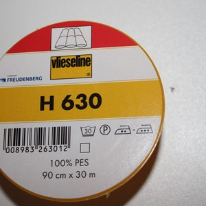 May include: A roll of white fusible interfacing labelled "vlieseline H 630" with a barcode, care instructions, and the text "100% PES 90 cm x 30 m".