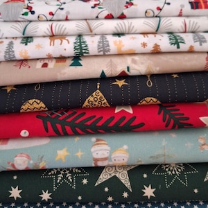 May include: A selection of Christmas-themed fabrics, featuring festive patterns. Designs include gnomes, Christmas trees, stars, and snowflakes in red, green, white, and blue. The fabrics are folded and stacked, displaying a range of seasonal prints.
