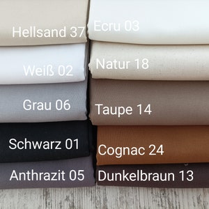 May include: A stack of fabric swatches in various shades of brown, gray, black, and white. The swatches are labeled with German names and numbers, such as "Hellsand 37", "Ecru 03", "Natur 18", "Wei&szlig; 02", "Grau 06", "Taupe 14", "Schwarz 01", "Cognac 24", "Anthrazit 05", and "Dunkelbraun 13".