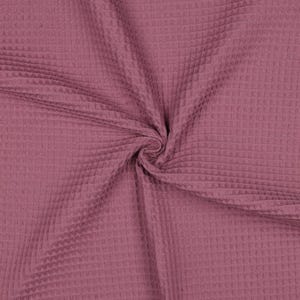 Pode incluir: Um tecido rosa empoeirado com uma textura distinta de tecido waffle. O material apresenta um padrão de grade criado pelas seções quadradas elevadas do tecido, resultando em uma superfície uniforme e tridimensional em toda a peça.