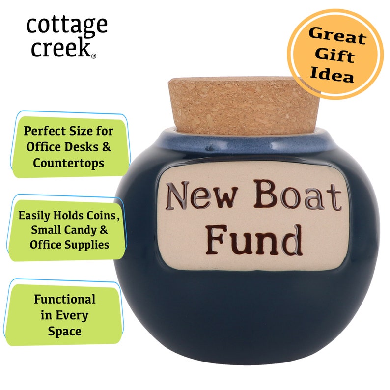 May include: A blue ceramic jar with a cork lid and a white label that reads "New Boat Fund". The jar is a great gift idea for someone saving up for a new boat.