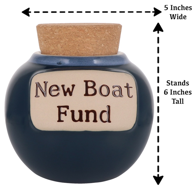 May include: Blue ceramic money box with a cork lid. It has a white label that says "New Boat Fund". The box stands 6 inches tall and is 5 inches wide.