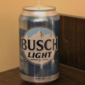 May include: A Busch Light beer can candle. The candle is in a silver and blue can with the Busch Light logo. The can is 12 fl oz. and has a white wick.