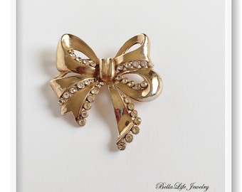 Stort band med rosett och guldfärgad strassbrosch