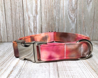 May include: A pink and orange tie-dye dog collar with a silver buckle and D-ring.