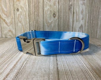 Puede incluir: Un collar para perro de color azul y blanco tie-dye con una hebilla y un anillo en D plateados.