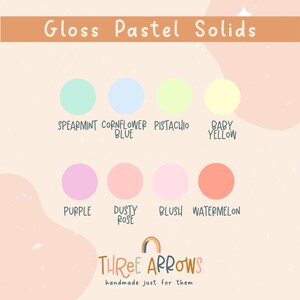 Puede incluir: Una paleta de colores titulada "Gloss Pastel Solids" con ocho colores pastel: menta, azul aciano, pistacho, amarillo beb&eacute;, morado, rosa empolvado, rubor y sand&iacute;a. La marca "Three Arrows" est&aacute; en la parte inferior.