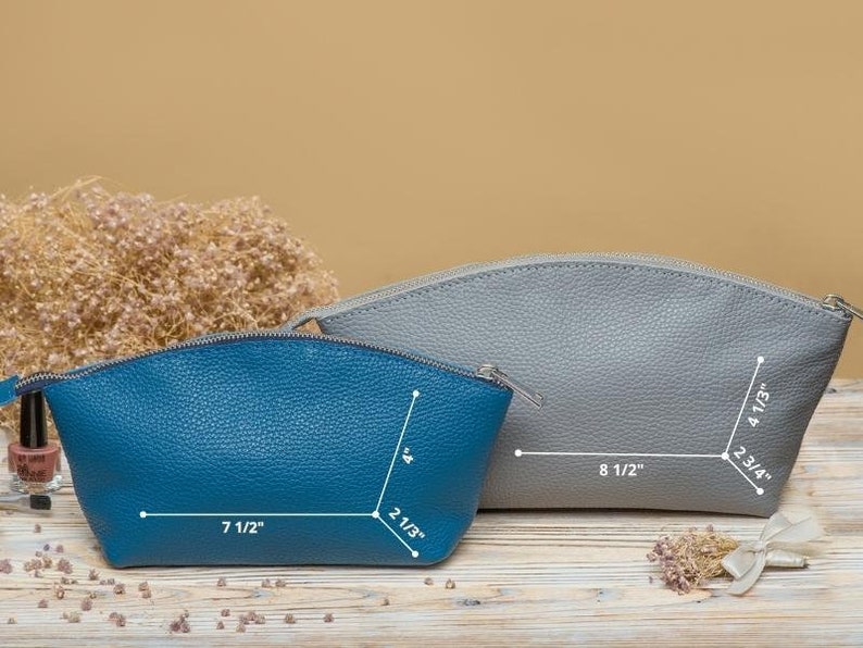 May include: Two leather cosmetic bags, one blue and one gray, with measurements in inches. The bags are on a wooden surface.
