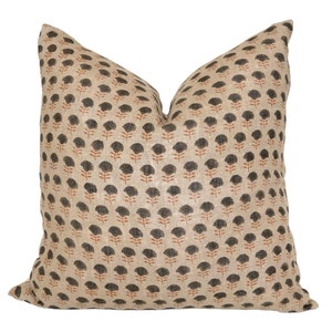 May include: A beige linen pillow with a black and orange floral print. The pillow is square and has a simple design.