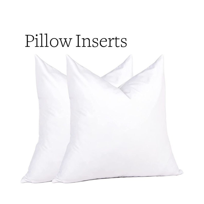 May include: Two white pillow inserts are displayed against a white background. The text "Pillow Inserts" is above the pillows. The pillows are square and have a soft, fluffy appearance, suggesting a comfortable design for home decor.