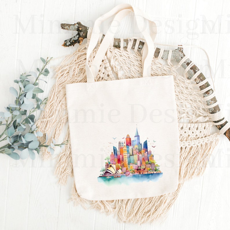 Pu&ograve; includere: Una borsa tote in tela bianca con un'illustrazione ad acquerello dello skyline di Sydney, tra cui l'Opera House di Sydney. L'illustrazione &egrave; in tonalit&agrave; di blu, verde, giallo, arancione, rosso e viola.