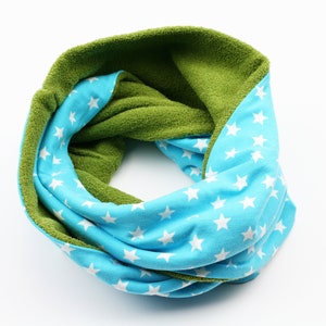 Könnte beinhalten: Ein wendbarer Halsschmeichler mit einer grünen Fleece-Seite und einer blauen Seite mit weißen Sternen.