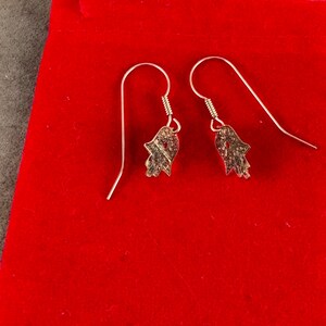 14 Karat Yellow Gold Hamsa Earrings with French Wires Hamsa is .625 in tall with Ear Wires 1.125 tall Shipped USPS Mail 
 The hamsa, or hamsa hand, is a talisman from the ancient Middle East. In its most common form, the amulet is shaped like a hand with three extended fingers in the middle and a curved thumb or pinky finger on either side. It is thought to protect against the “evil eye." It is most often displayed on necklaces or bracelets, and earrings