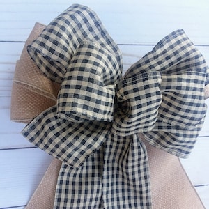 May include: A large black and tan gingham bow with a burlap ribbon.