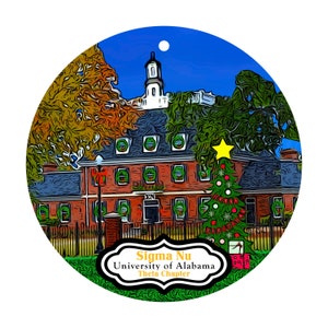 May include: Round Christmas ornament featuring a brick building with a white tower, a decorated Christmas tree, and the text "Sigma Nu University of Alabama Theta Chapter." The ornament has a blue sky background.