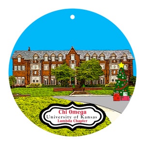 May include: A round Christmas ornament featuring a brick building with a Christmas tree and presents. The ornament has a blue sky background and the text "Chi Omega University of Kansas Lambda Chapter".