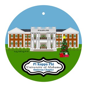 May include: A round Christmas ornament featuring a detailed illustration of a building with the text "PI KAPPA PHI" above the entrance. A Christmas tree and gifts are on the right. The ornament also includes the text "Pi Kappa Phi University of Alabama Omicron Chapter".