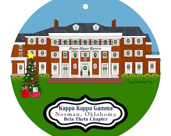 May include: A round Christmas ornament featuring a brown building with white columns and shutters, adorned with wreaths. The text "Kappa Kappa Gamma" is above the entrance. A Christmas tree and gifts are on the left, and the text "Kappa Kappa Gamma Norman, Oklahoma Beta Theta Chapter" is below.