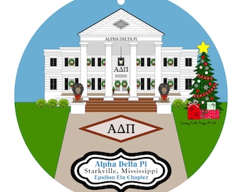 Könnte beinhalten: Runder Weihnachtsschmuck mit einem weißen Gebäude mit Säulen, den Worten "ALPHA DELTA PI" darüber und den griechischen Buchstaben ΑΔΠ. Ein Weihnachtsbaum und Geschenke befinden sich auf der rechten Seite. Der Text "Alpha Delta Pi Starkville, Mississippi Epsilon Eta Chapter" steht darunter.
