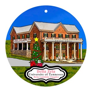 May include: A round Christmas ornament featuring a brick building with white columns and the text "Delta Zeta University of Tennessee Beta Lambda Chapter." A decorated Christmas tree and presents are in front of the building.
