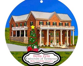 May include: A round Christmas ornament featuring a brick building with white columns and the text "Delta Zeta University of Tennessee Beta Lambda Chapter." A decorated Christmas tree and presents are in front of the building.