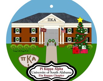 May include: A round Christmas ornament featuring a building with the letters "ΠΚΑ" above the entrance. The ornament includes a Christmas tree, gifts, and the text "Pi Kappa Alpha, University of South Alabama, Eta Kappa Chapter".