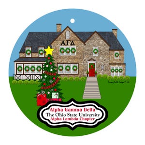 May include: A round Christmas ornament featuring a stone house with wreaths on the windows and a decorated Christmas tree. The ornament has the text "Alpha Gamma Delta, The Ohio State University, Alpha Lambda Chapter."