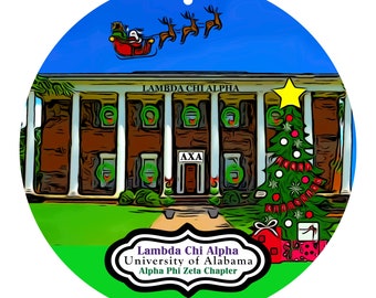 Könnte beinhalten: Runder Weihnachtsschmuck mit einem Gebäude mit der Aufschrift "LAMBDA CHI ALPHA" und einem Weihnachtsbaum. Der Schlitten des Weihnachtsmanns und Rentiere fliegen darüber. Der Schmuck enthält auch den Text "Lambda Chi Alpha University of Alabama Alpha Phi Zeta Chapter".
