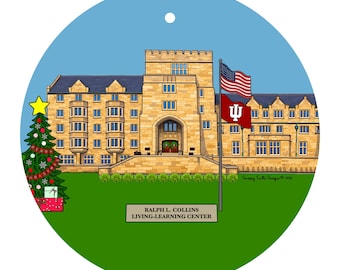 Könnte beinhalten: Runder Weihnachtsschmuck mit einer detaillierten Illustration eines Universitätsgebäudes mit einer amerikanischen Flagge und einer Flagge mit einem weißen 'I' auf karmesinrotem Hintergrund. Ein dekorierter Weihnachtsbaum und der Text "RALPH L. COLLINS LIVING-LEARNING CENTER" sind ebenfalls zu sehen.