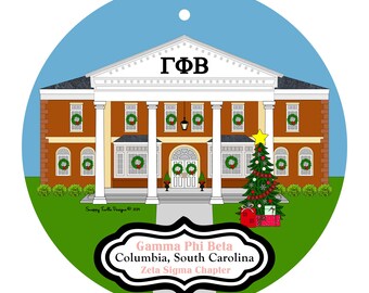 May include: A round Christmas ornament featuring a brown building with white columns and the Greek letters ΓΦΒ. The building has wreaths on the windows and a decorated Christmas tree. Text on the ornament reads "Gamma Phi Beta, Columbia, South Carolina, Zeta Sigma Chapter."
