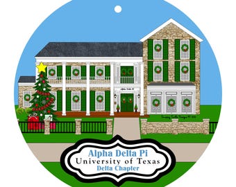 Könnte beinhalten: Runder Weihnachtsschmuck mit einer detaillierten Illustration eines zweistöckigen Hauses mit grünen Fensterläden und Kränzen. Ein Weihnachtsbaum und Geschenke befinden sich auf der linken Seite. Der Text "Alpha Delta Pi University of Texas Delta Chapter" steht unten.