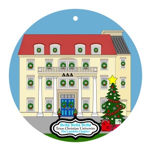 May include: A round Christmas ornament featuring a cream-colored building with a red roof and green wreaths on the windows. A decorated Christmas tree stands to the right. The text "Delta Delta Delta Texas Christian University Phi Lambda Chapter" is below the building.