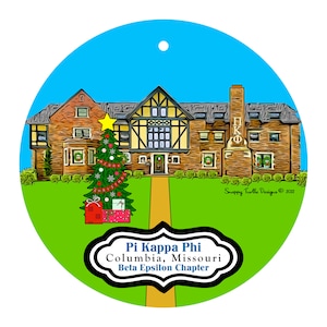 May include: Round Christmas ornament featuring a detailed illustration of a building with a Christmas tree and presents. The ornament has a blue sky background and the text "Pi Kappa Phi Columbia, Missouri Beta Epsilon Chapter".