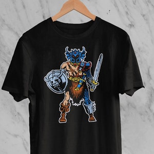 May include: Black t-shirt featuring a cartoon warrior with a helmet, shield, and sword. The warrior is depicted in shades of blue, brown, and tan. The shield has a skull design. The shirt is hanging on a wooden hanger.