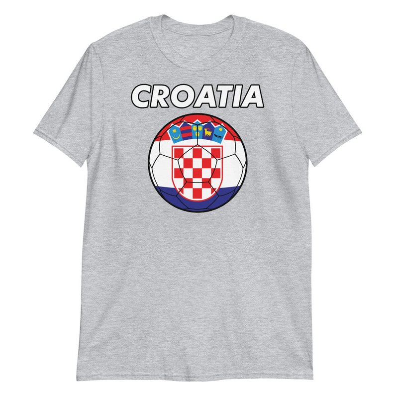 May include: A light gray t-shirt featuring the word "CROATIA" in white block letters above a soccer ball design. The soccer ball is in the colors of the Croatian flag, with a red and white checkered pattern.