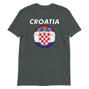 May include: Dark gray t-shirt featuring the word "CROATIA" in white block letters above a soccer ball design. The soccer ball displays the Croatian flag's red and white checkered pattern, with a blue and red border.