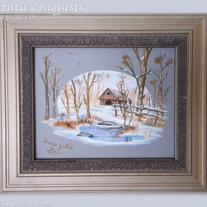 May include: A framed painting of a winter scene with a small wooden cabin, trees, and a frozen pond. The painting is signed "Duane West" in the lower right corner. The frame is a light gold color with a decorative border.