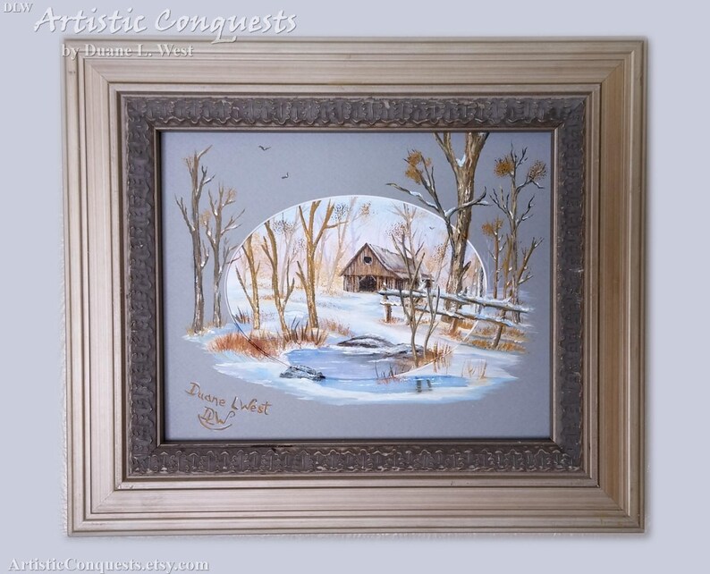 May include: A framed painting of a winter scene with a small wooden cabin, trees, and a frozen pond. The painting is signed "Duane West" in the lower right corner. The frame is a light gold color with a decorative border.