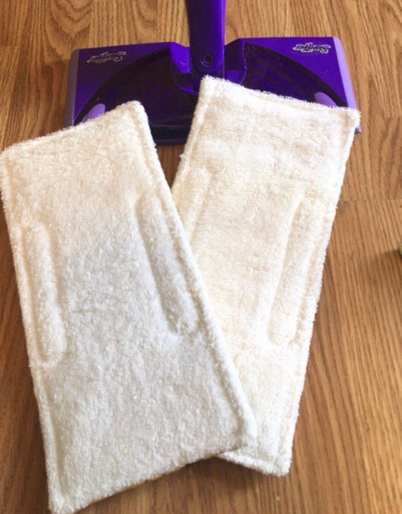 May include: Two white microfiber mop pads for a Swiffer WetJet mop. The pads are made of a soft, absorbent material and are designed to clean and polish floors.