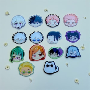May include: A collection of fourteen circular and custom-shaped pin-back buttons featuring colorful anime-style character illustrations. The designs include various facial expressions, hair colors, and accessories like glasses, arranged in a grid pattern.