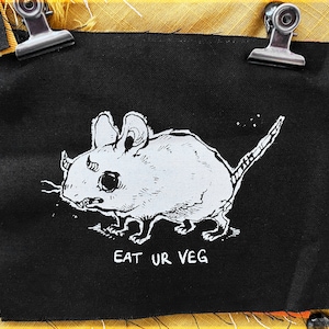 May include: Black and white iron-on patch featuring a cartoon mouse with the text "EAT UR VEG" underneath.