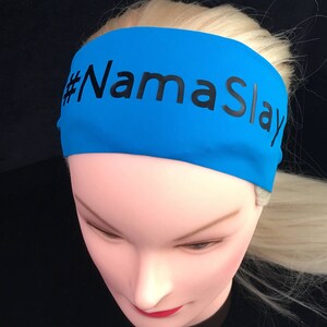 K&ouml;nnte beinhalten: Ein leuchtend blaues Stirnband mit dem Text "#NamaSlay" in Schwarz.