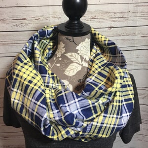 May include: A yellow, blue, and white plaid infinity scarf. The scarf is made of a soft, comfortable fabric and is perfect for adding a touch of style to any outfit.