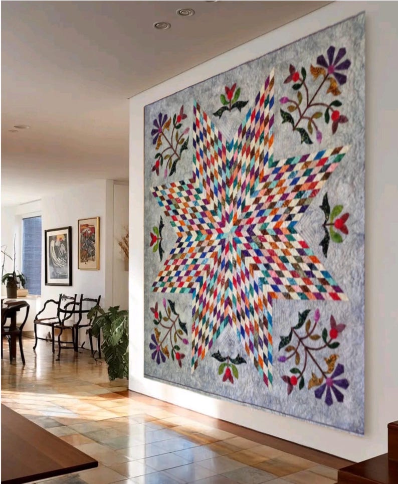 May include: A large wall quilt featuring a central multi-colored star pattern composed of small diamond-shaped fabric pieces. The star is set against a light gray background with floral motifs in the corners, including purple and red flowers.