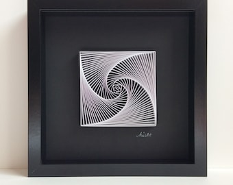 May include: A black framed wall art piece featuring a white paper spiral design with a light purple hue. The design is framed against a black background and signed "MiiArt" in the bottom right corner.