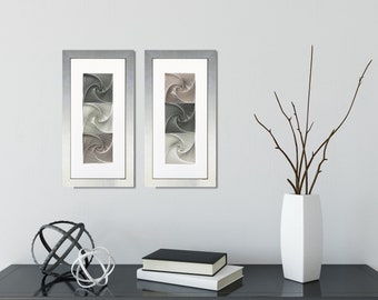 May include: Two framed abstract art prints featuring a swirling pattern in shades of grey and brown. The prints are hanging on a white wall above a black table with a vase of branches and two decorative spheres.