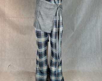May include: A pair of blue and white plaid pants with a gray wrap skirt tied around the waist.