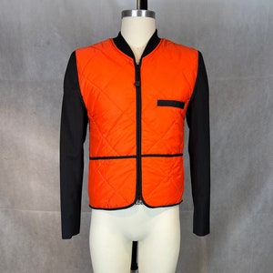 Il tuo nuovo mashup nella giungla urbana: gilet da caccia arancione e blazer nero da uomo. Crea la tua giacca dell&#39;uniforme cittadina